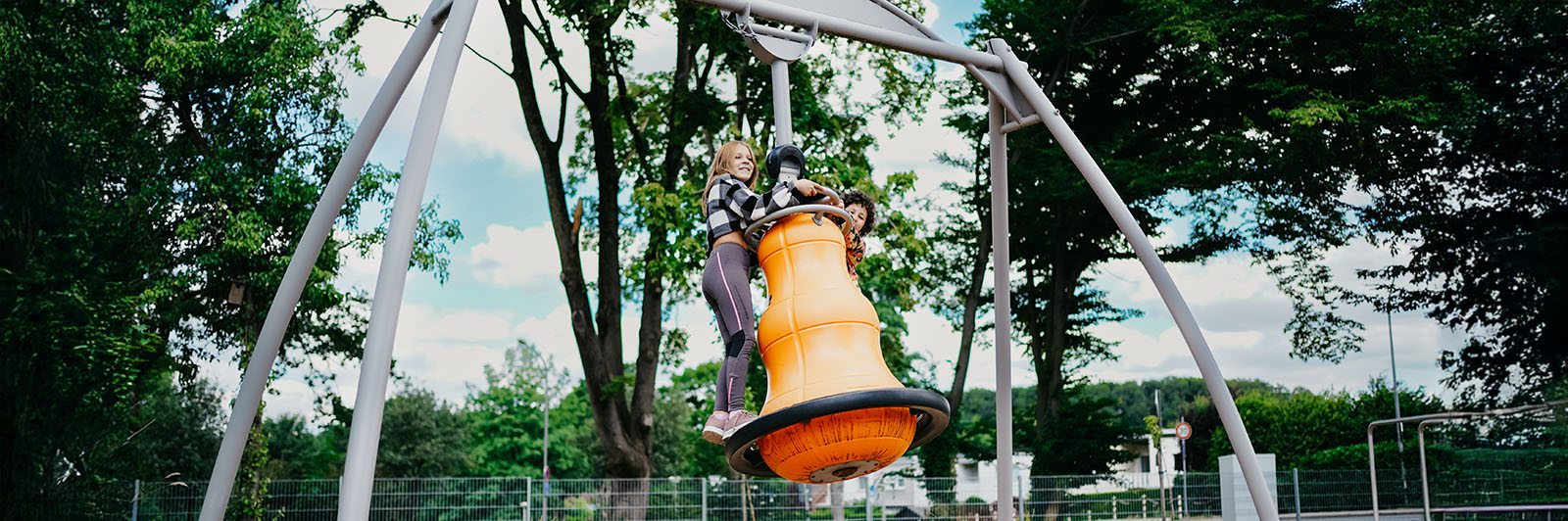 Two girls swinging on an Agito swing.